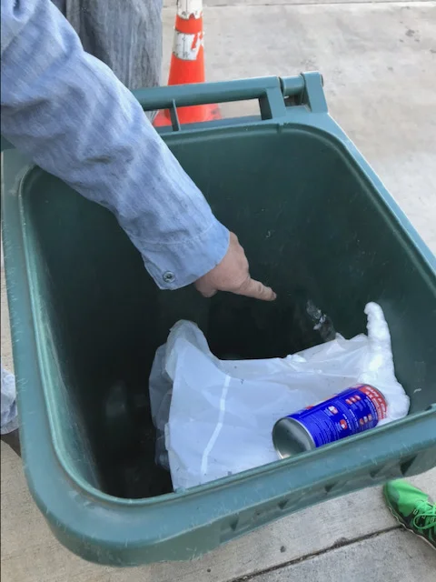 The trash can where the kitten was stuck, suspended from his rear legs.