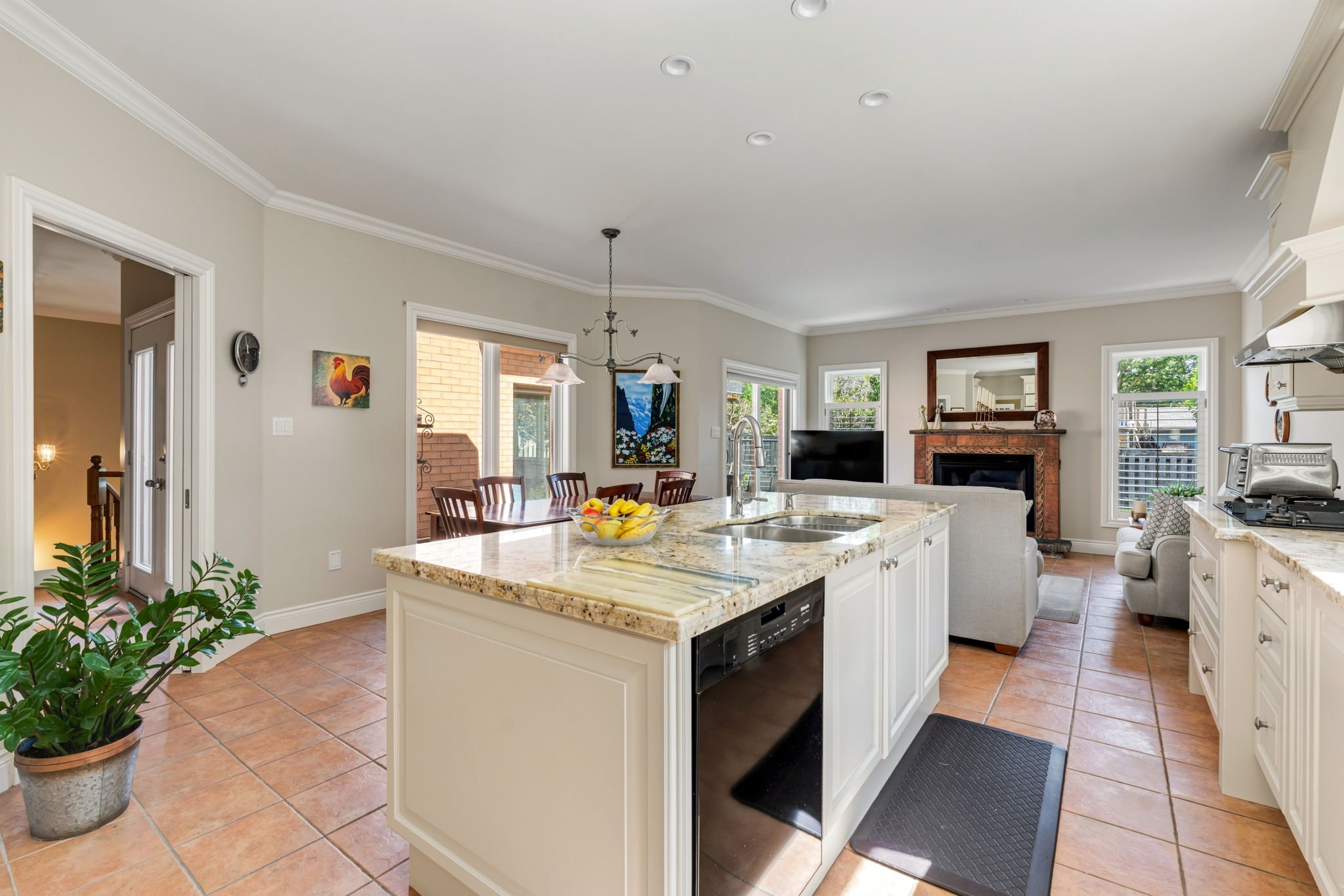Kitchen centre island looking through to the family room fireplace beyond