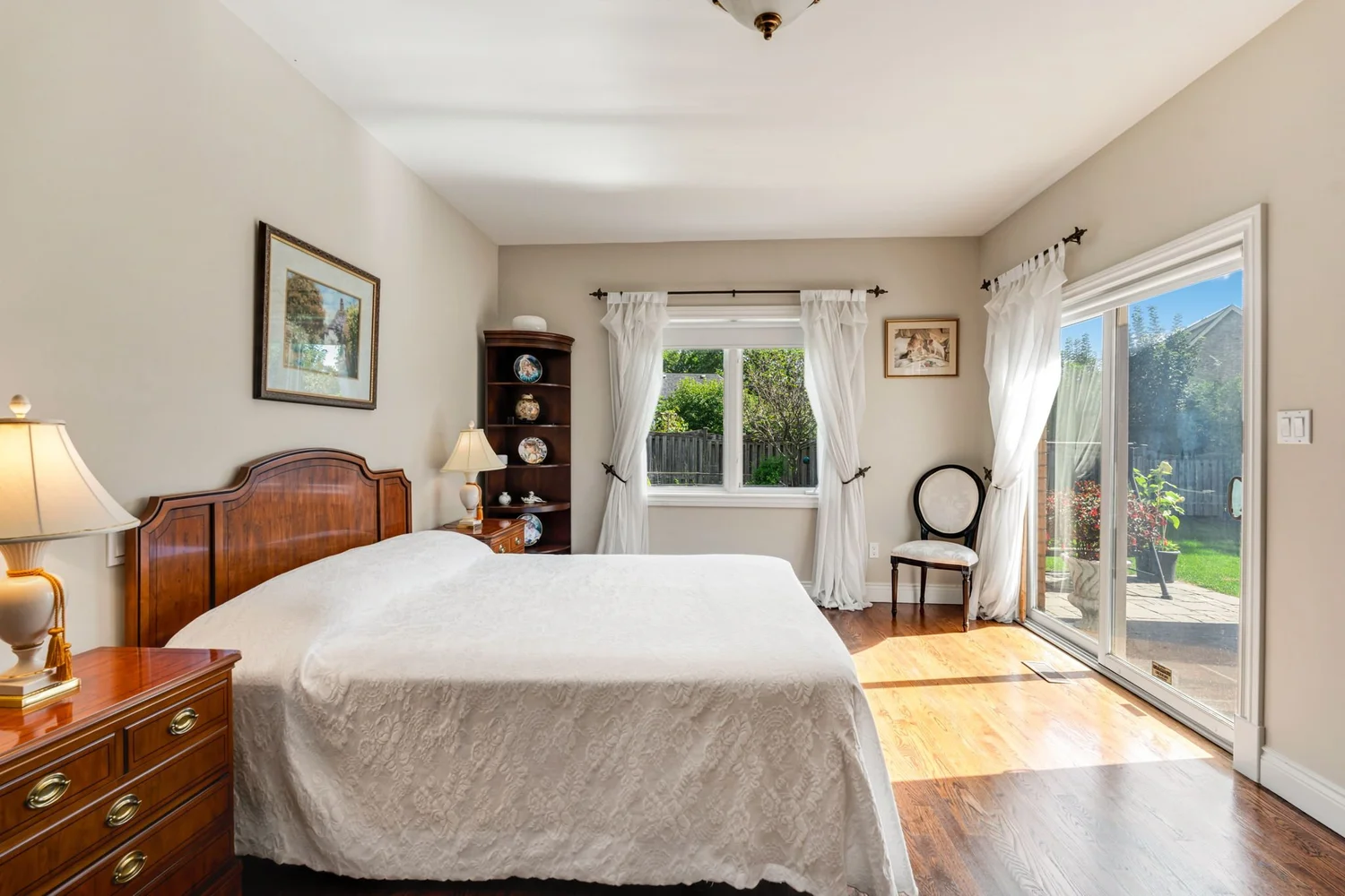 Primary bedroom with hardwood floors and sliding glass doors opening to the rear garden