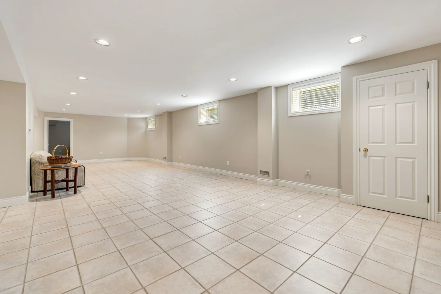 Expansive open recreation room on the lower level with pot lights and tile flooring