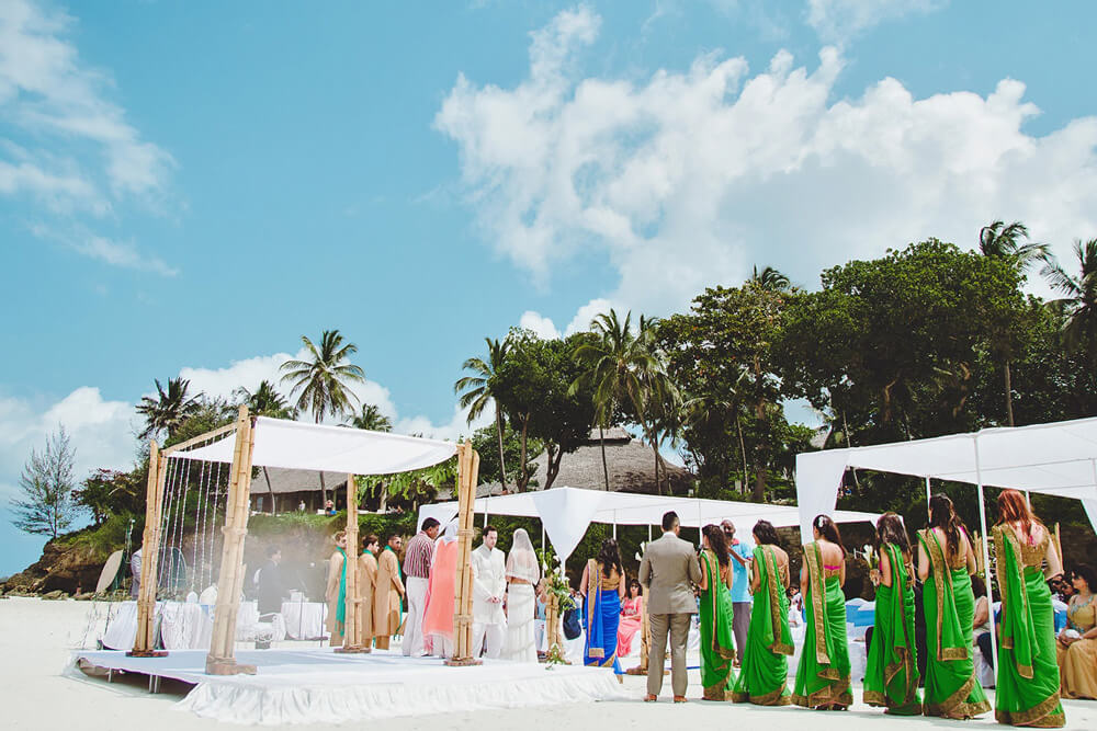 The bride and groom look at each other happily during the ceremony. Diani Beach Destination Wedding  Kenyan coast photographer Destination Wedding Photography Kenyan Wedding Award Winning Fashion Female Destination Kenyan Top Kenya Wedding Photographer