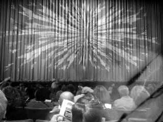 Curtain and patrons waiting for the show to begin.