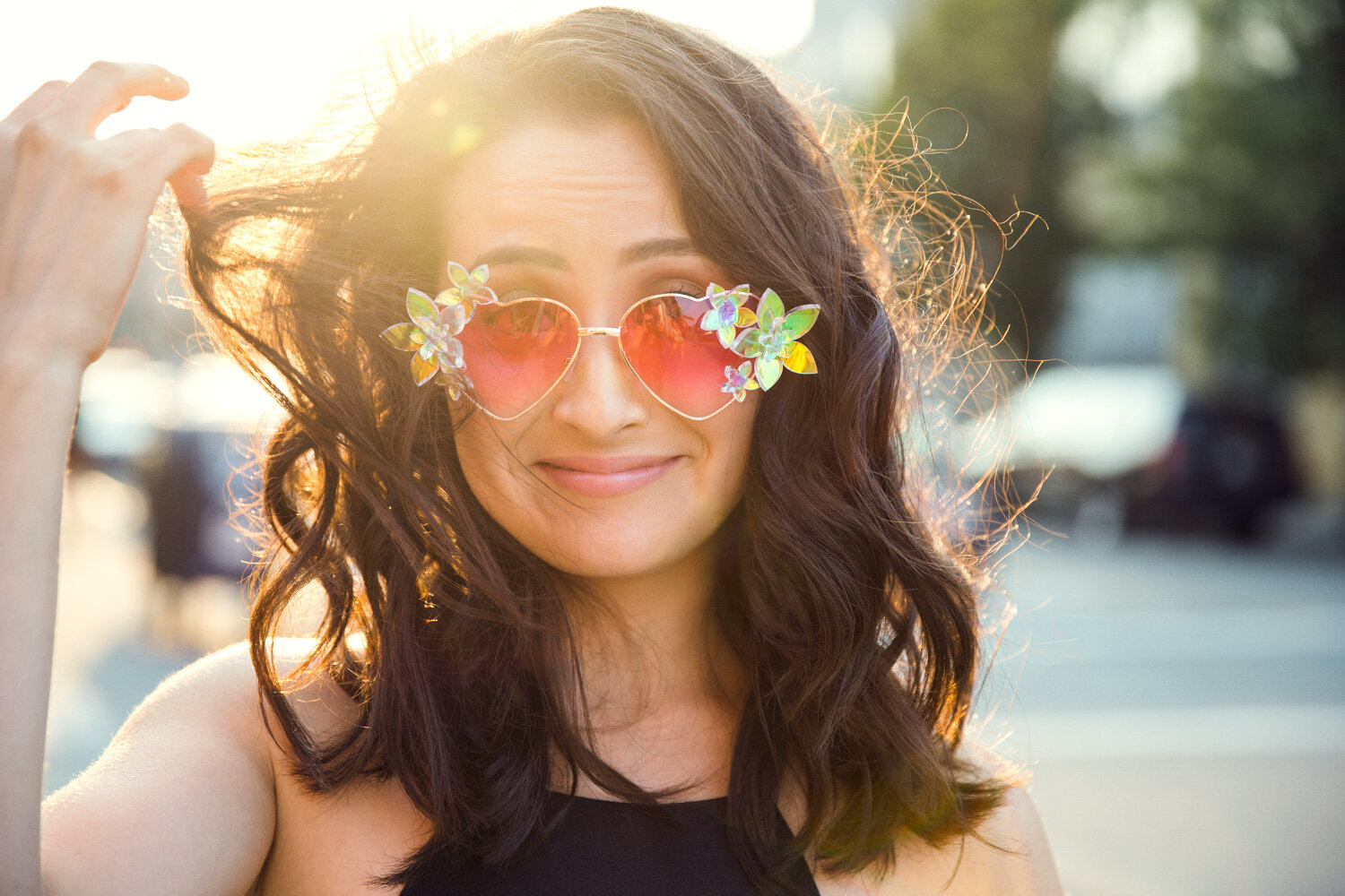 beautiful and quirky promotional photo of comedian with hair caught in heart shaped sunglasses