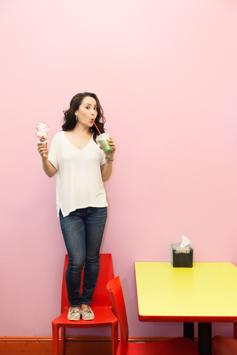 quirky portrait of comedian Catherine Geller sipping green juice while holding an ice cream cone