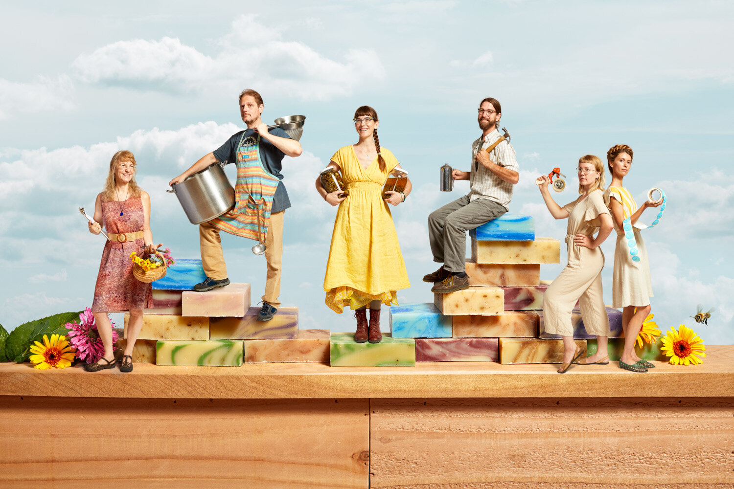 conceptual team portrait of home and body care company LuSa Organics showing team members standing on giant soap blocks composited together by conceptual photographer Hanna Agar