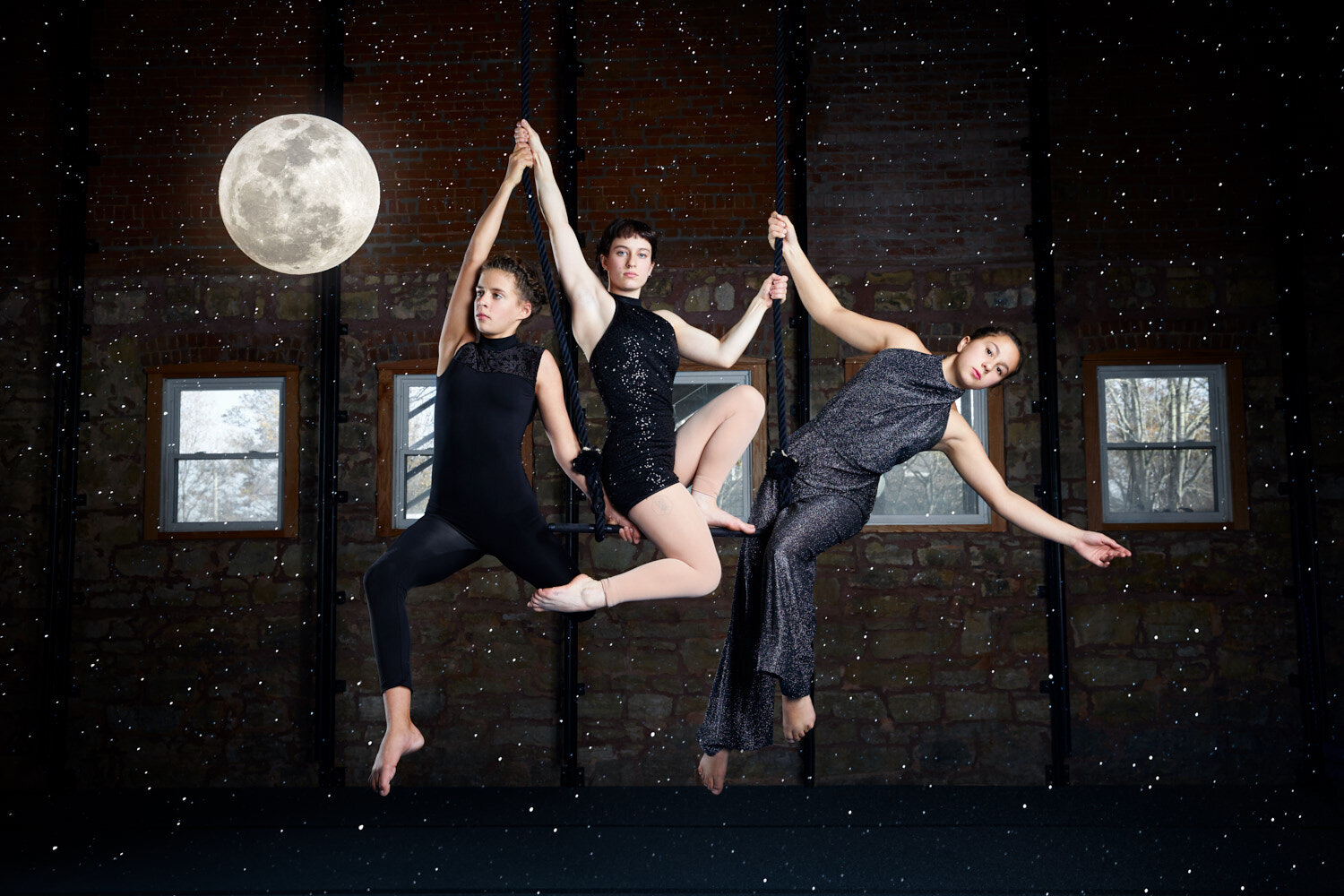 entertainer photography: arial performers posed on trapeze with full moon and stars