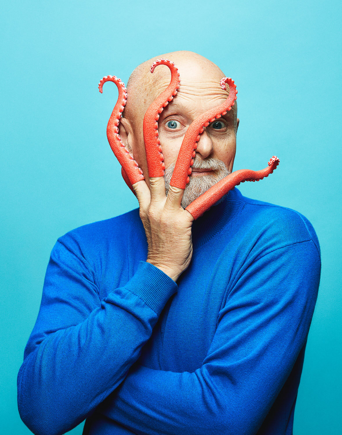 quirky portrait of composer William Neil peaking through octopus tentacles that he is wearing on his fingers by portrait photographer Hanna Agar