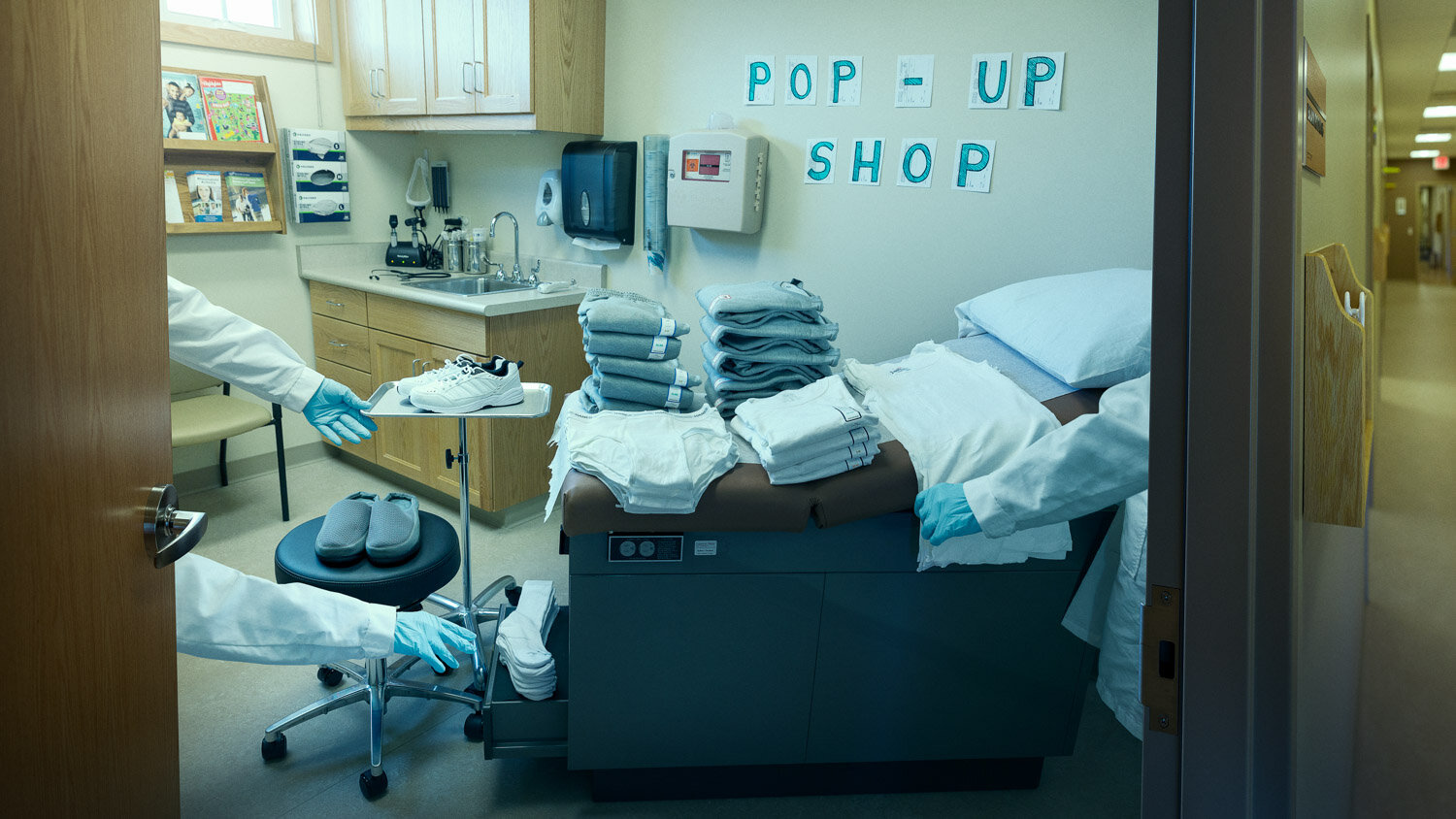 editorial product photography: sterile hospital room is set up as pop-up shop for generic clothing for the disabled. 