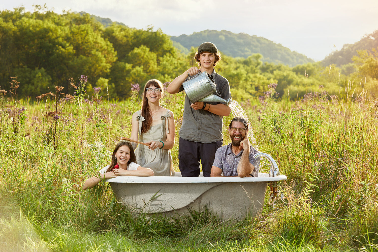 creative commercial portrait: LuSa Organics family in a bathtub in a field with rolling hills of Wisconsin's Driftless Region.