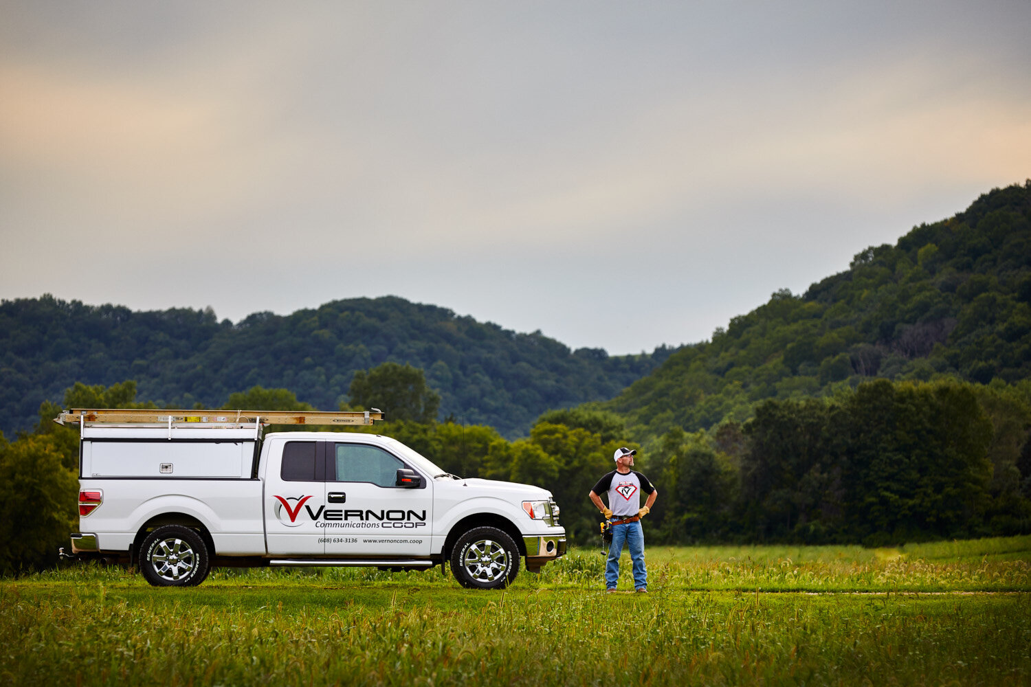 advertising image for communications company: technician posed heroically with truck in the rolling hills of Wisconsin's Driftless Region