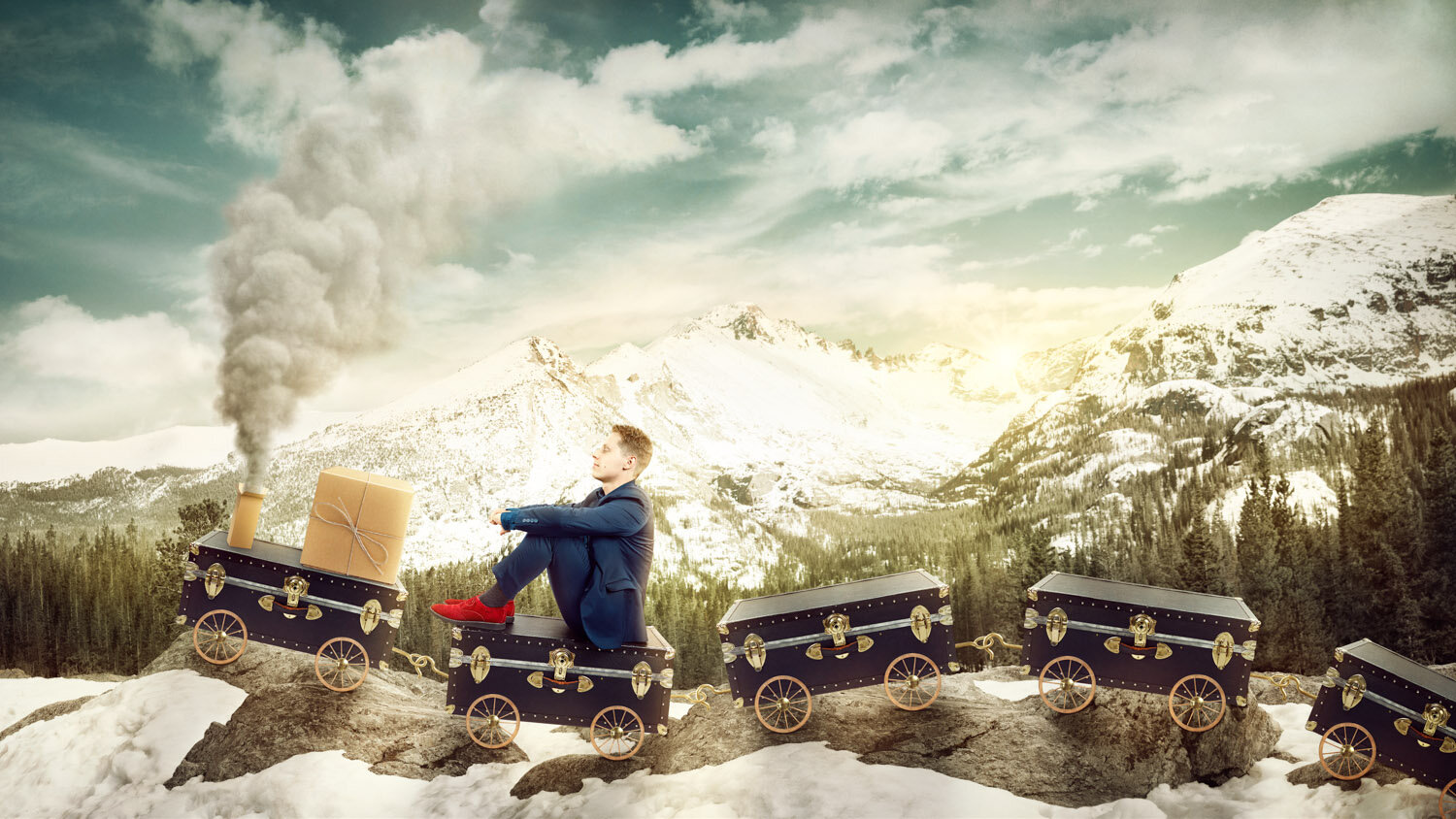 conceptual portrait of magician Ben Seidman riding a train made of vintage trunks through the Rocky Mountains by portrait photographer Hanna Agar
