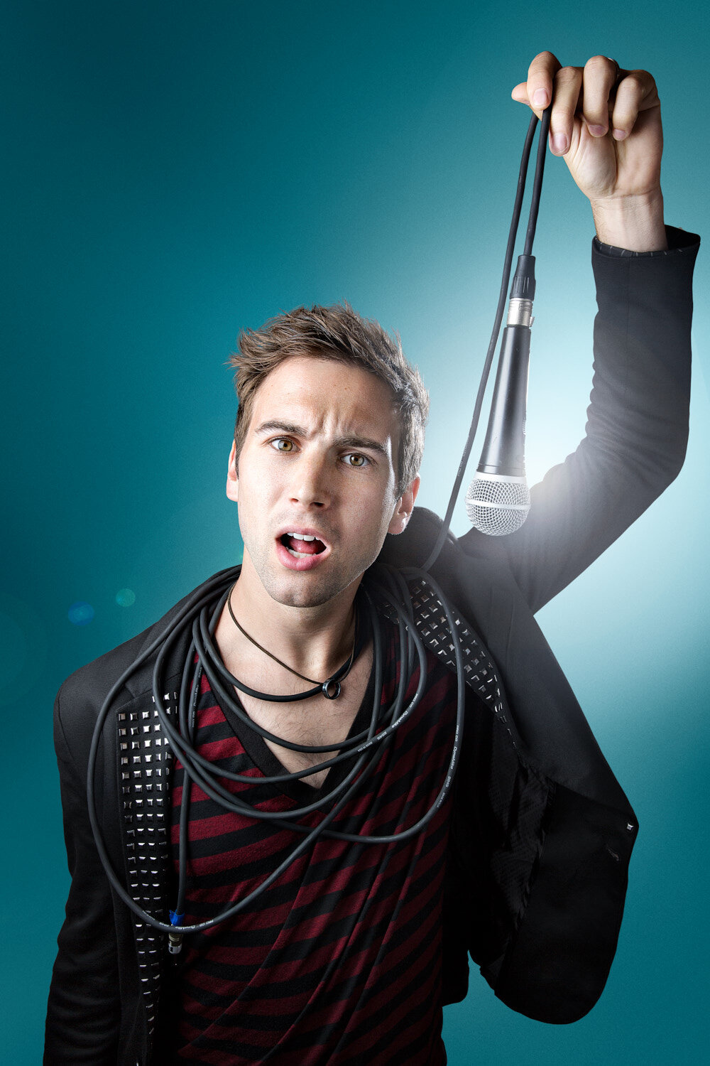 promo photo of juggler Marcus Monroe holding microphone with cord wrapped around his neck by studio portrait photographer Hanna Agar