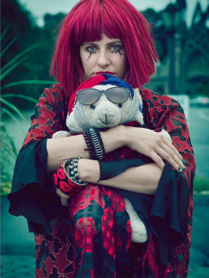 quirky portrait of entertainer Michelle Joni with red wig and teddy bear by creative portrait photographer Hanna Agar