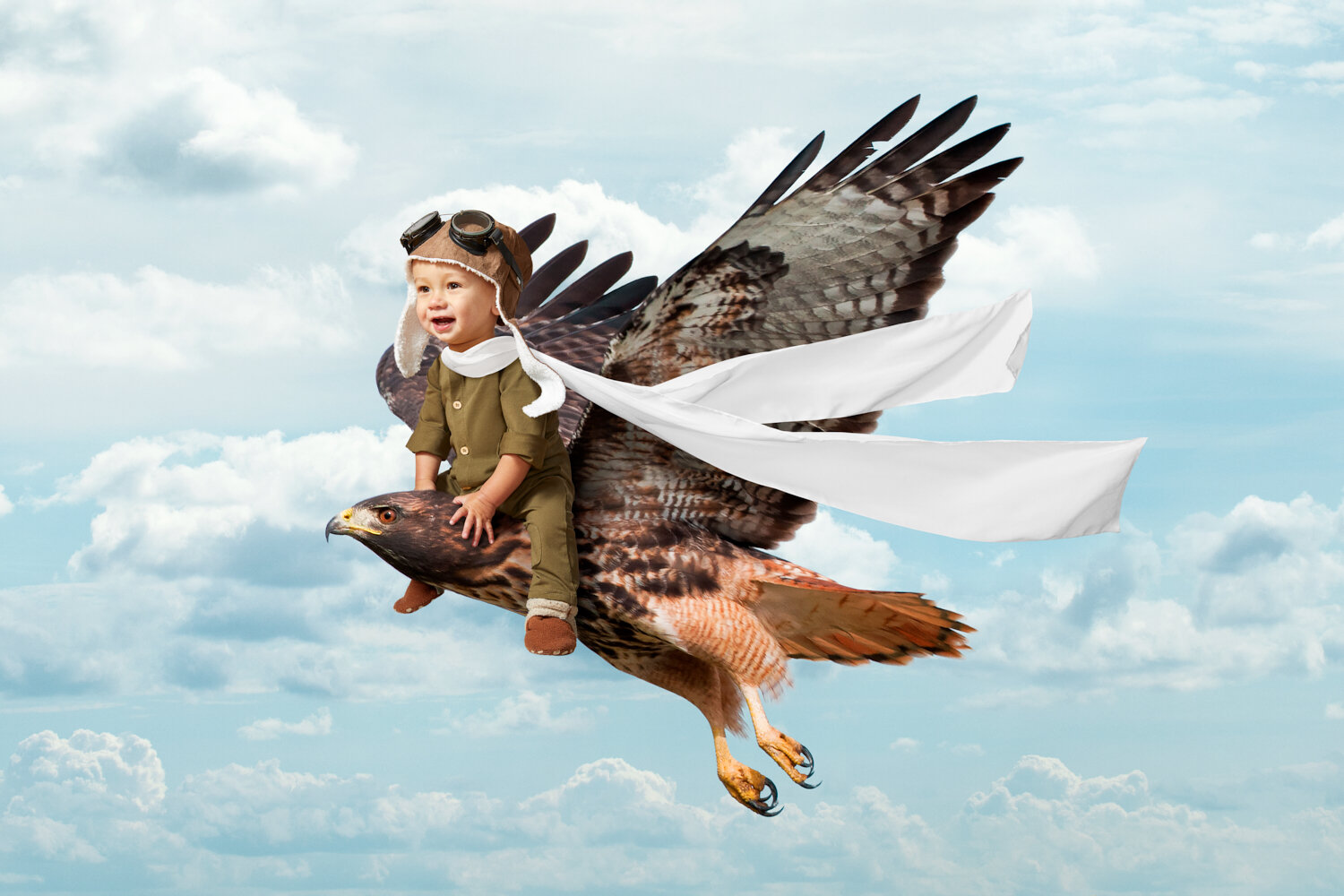 creative portrait of a little boy dressed as an aviator riding a hawk through the sky by conceptual portrait photographer Hanna Agar