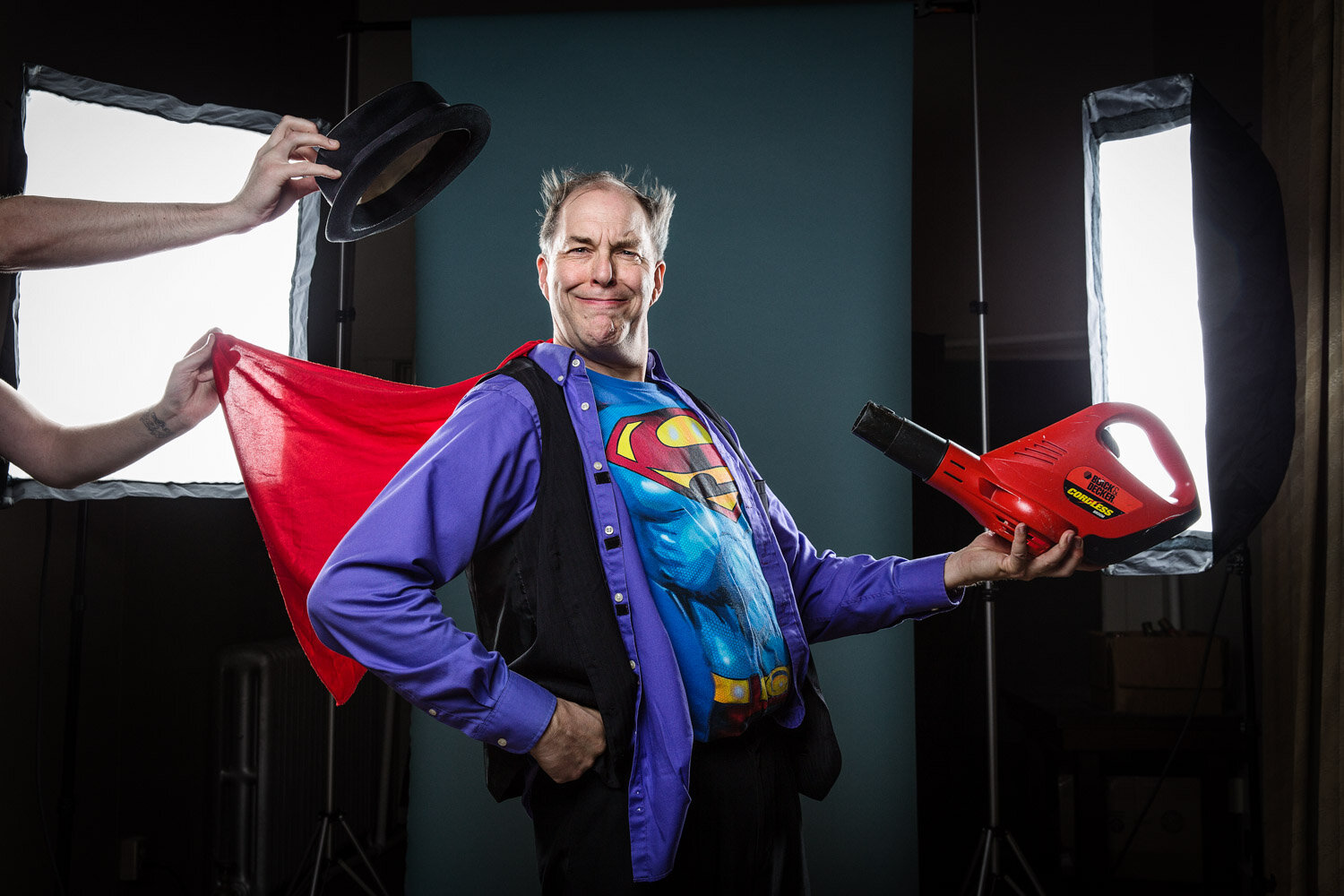 quirky promotional photo of juggler Steve Russell  dressed as superman holding a leaf blower by creative portrait photographer Hanna Agar