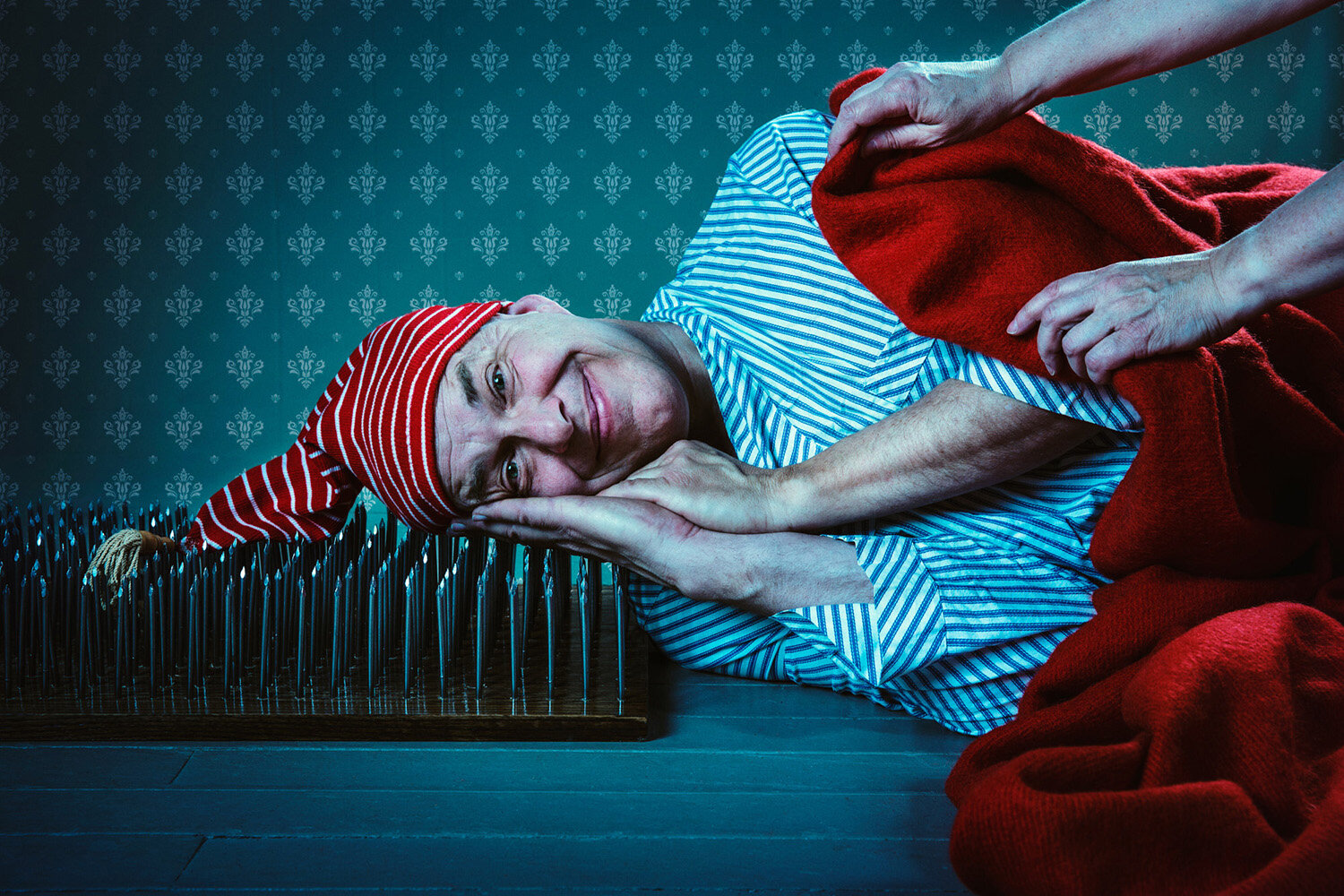 silly promotional photo of juggler Steve Russel sleeping on a bed of nails by creative portrait photographer Hanna Agar