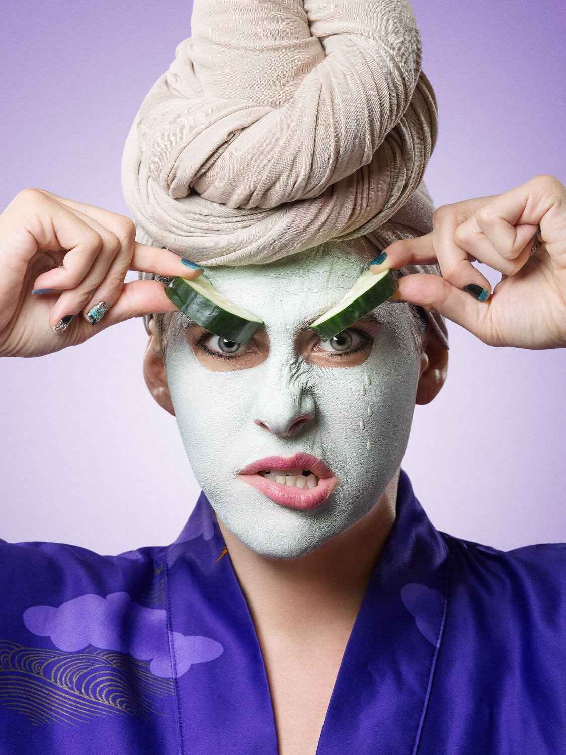 performer Michelle Joni has mud mask and cucumber scowl; creative beauty portrait to promote her business by creative portrait photographer Hanna Agar