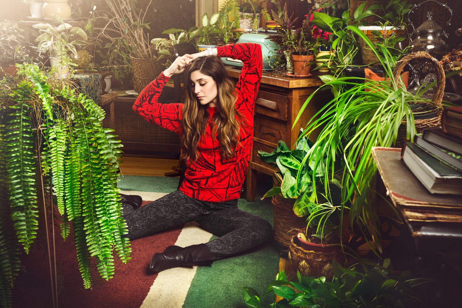 whimsical portrait of musician sitting in vintage hotel surrounded by plants by band photographer Hanna Agar