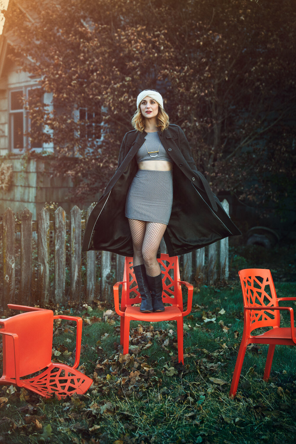 musician Elizabeth Ghandour stands outside on an orange chair by band photographer Hanna Agar