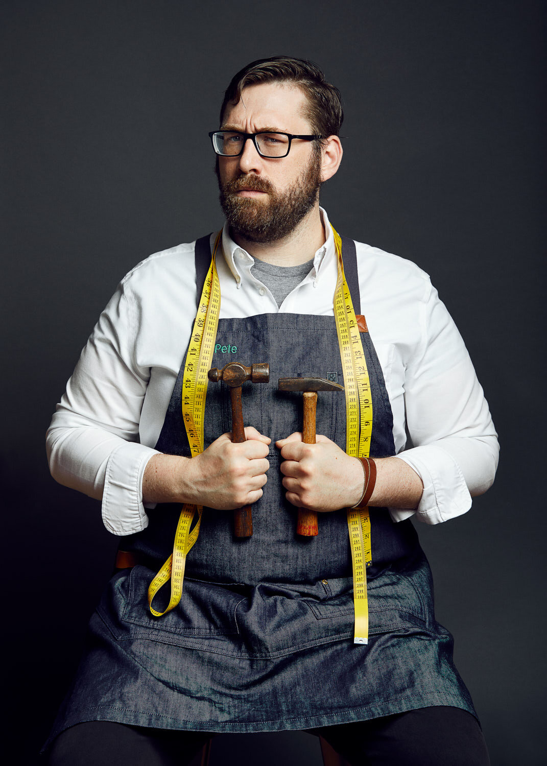 quirky portrait of leather worker holding tools by studio portrait photographer Hanna Agar
