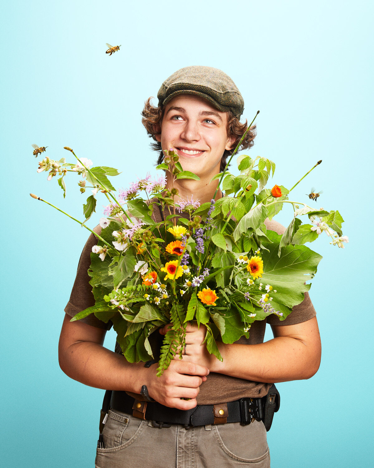 whimsical studio portrait of boy with giant flower bouquet by studio portrait photographer Hanna Agar