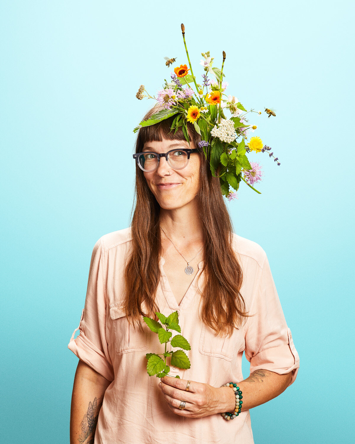 whimsical studio portrait of woman with beautiful flower headpiece by creative portrait photographer Hanna Agar