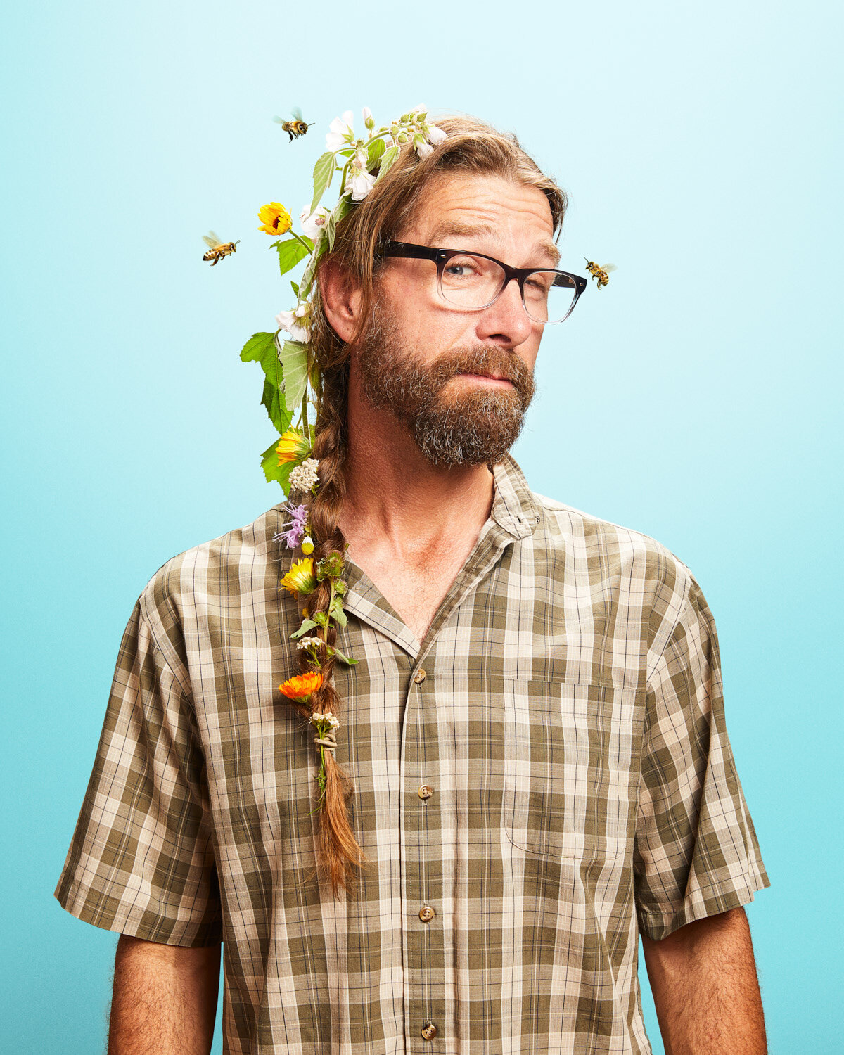 whimsical studio portrait of man with beautiful flower braid by creative portrait photographer Hanna Agar