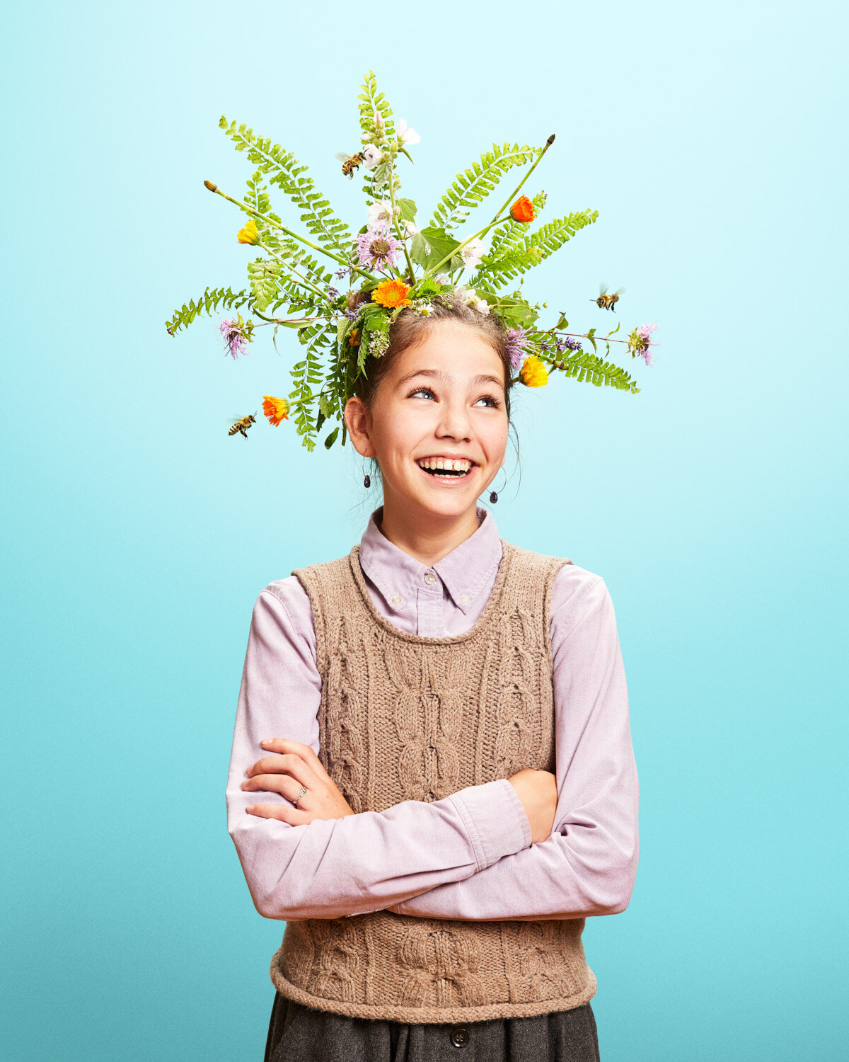 whimsical studio portrait of girl with giant flower headpiece by creative portrait photographer Hanna Agar