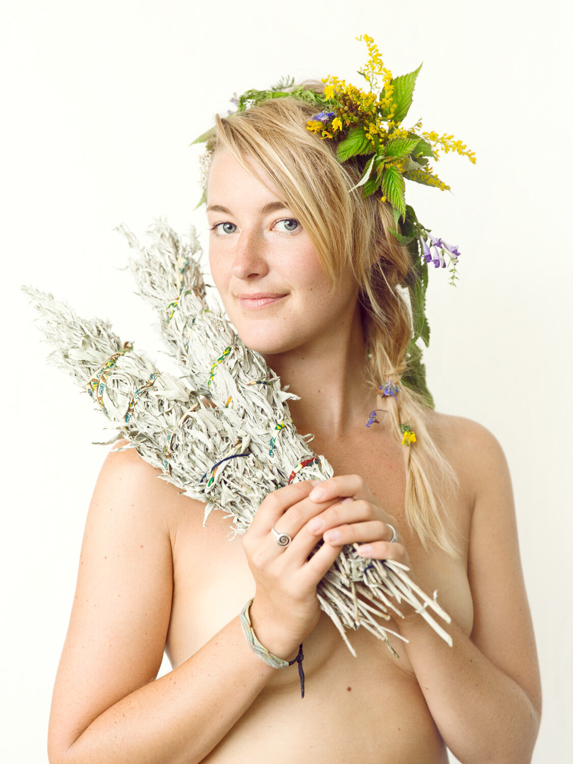 beautiful portrait of herbalist holding giant sage smudge sticks by portrait photographer Hanna Agar