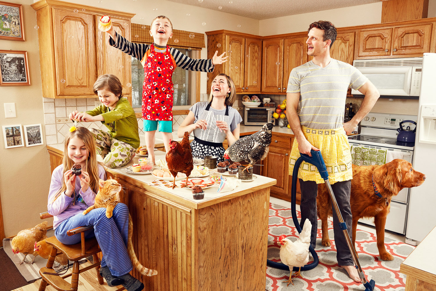 happy family baking in messy kitchen with chickens, cat and dog by commercial portrait photographer Hanna Agar