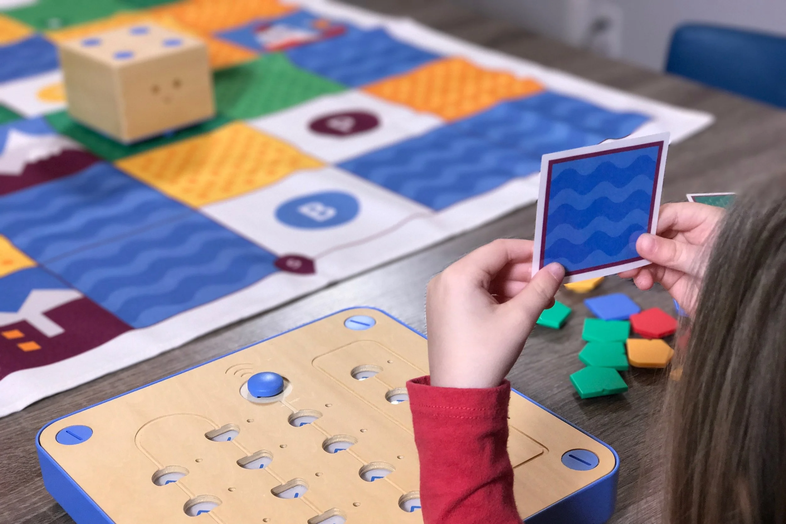 Girl holding a destination card for Cubetto's World Map