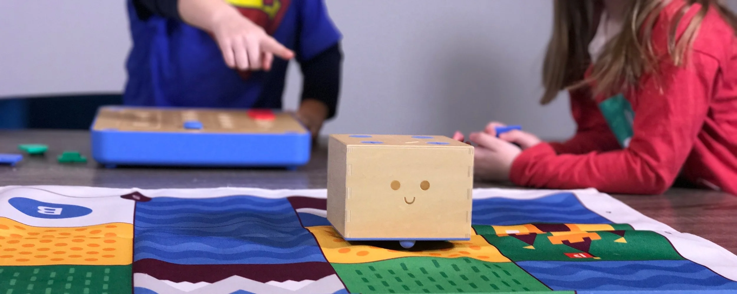 Two children with Cubetto