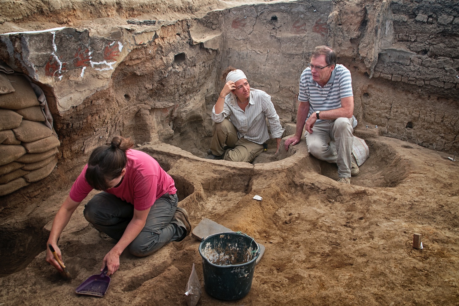  Burcu Tung and Ian Hodder discuss excavation plans in Building 77 (North Area) during the last days of the 2013 season. In the foreground, Renata Araujo cleans her area for a photo. 