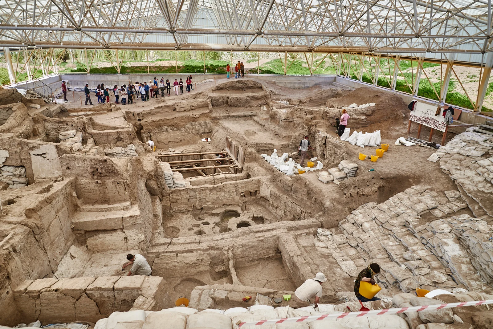 Excavation team cleans the South excavation area for the new season while children visit the site.