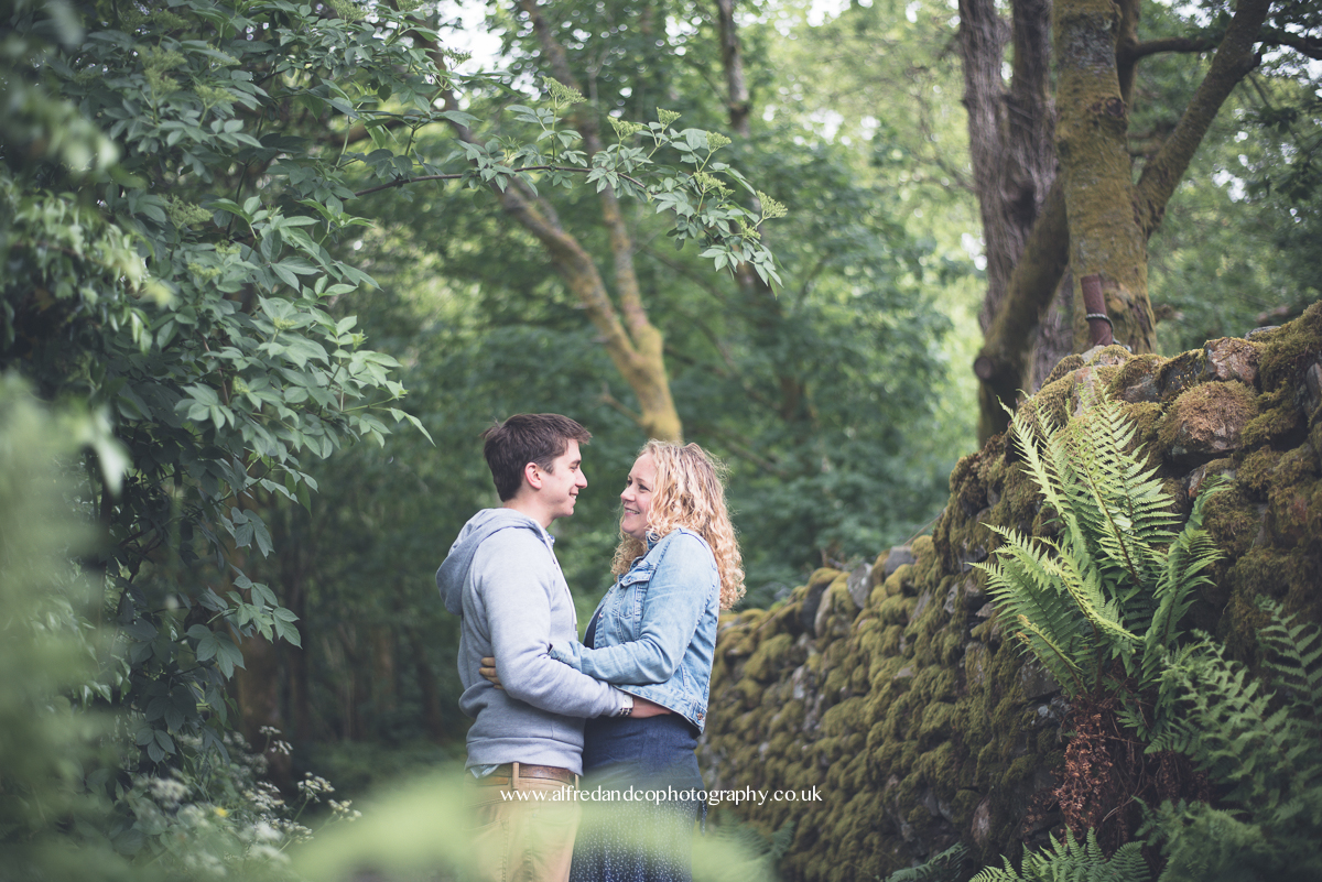 couple posing between trees