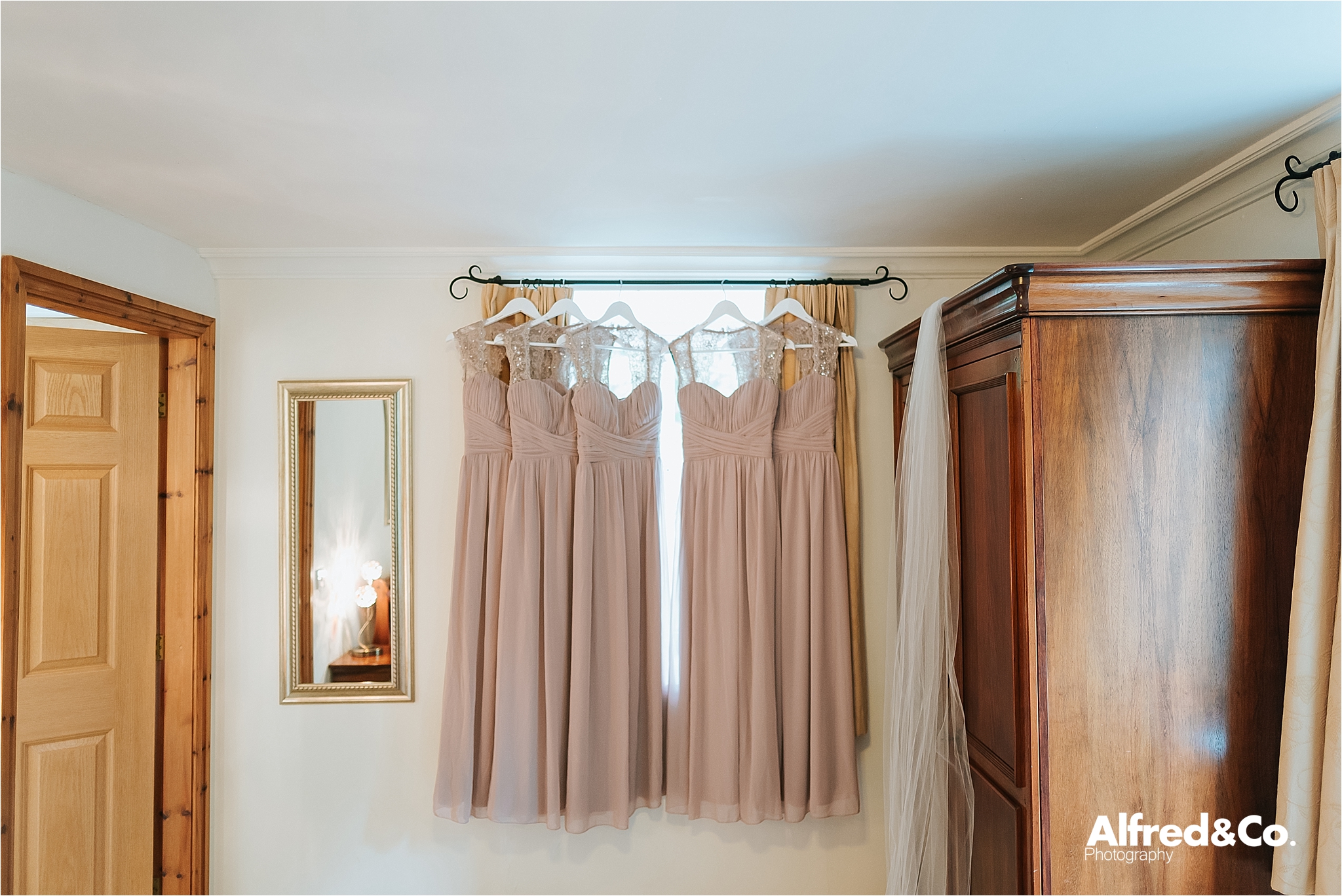 bridesmaids dresses hanging in window 