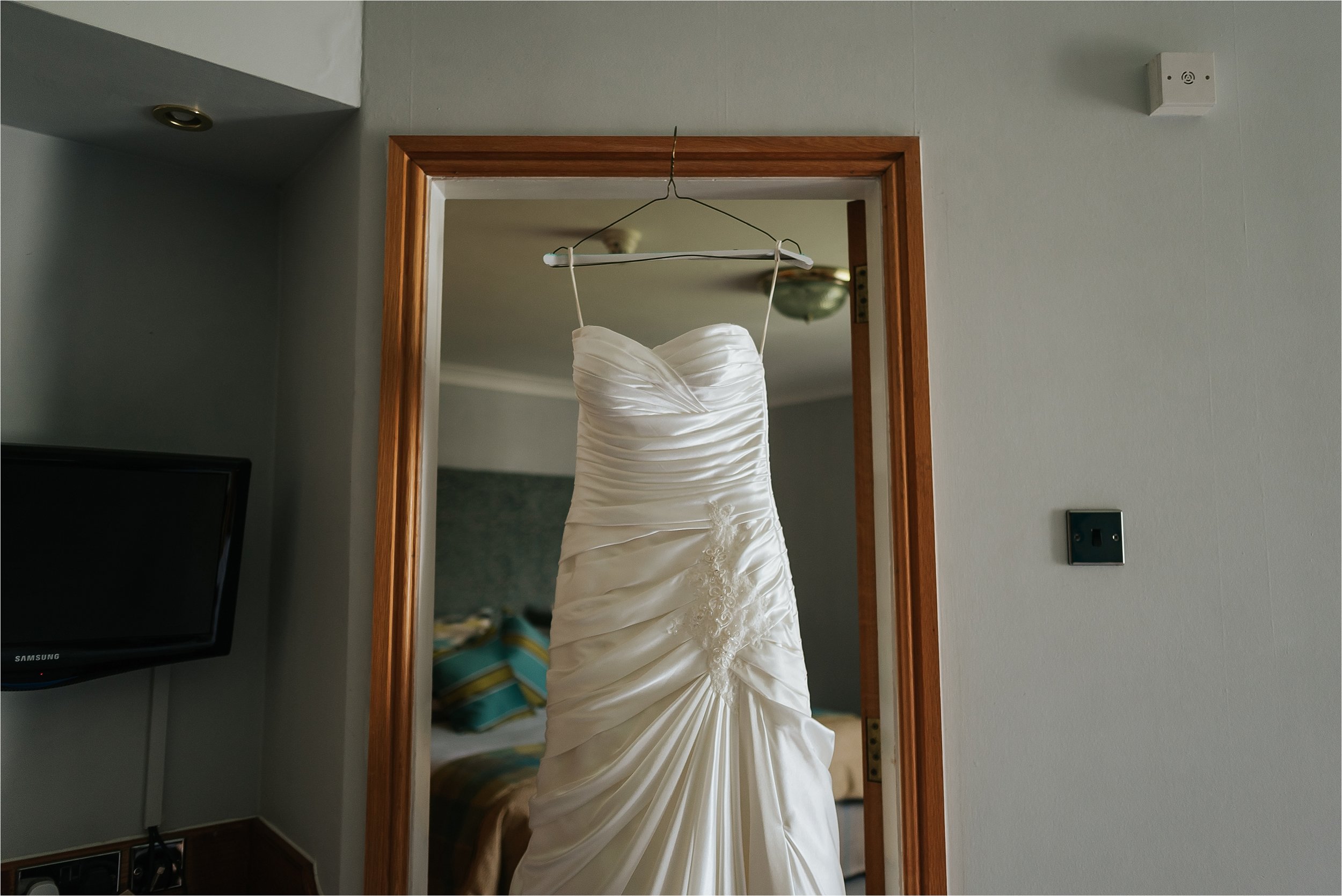 wedding dress hanging in door way 