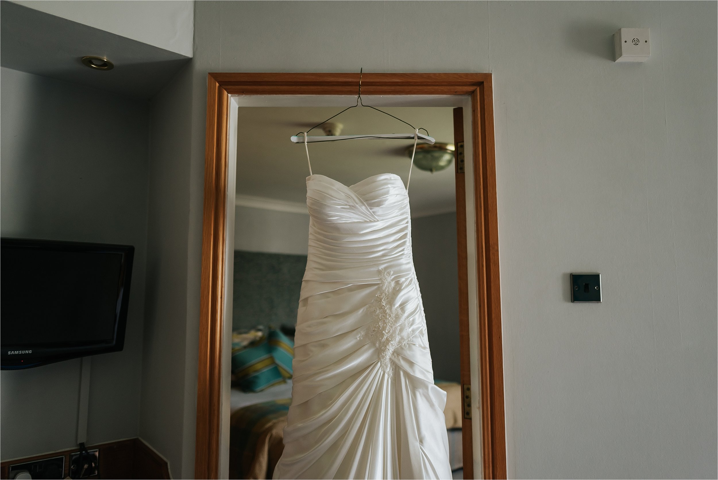 wedding dress hanging in door way