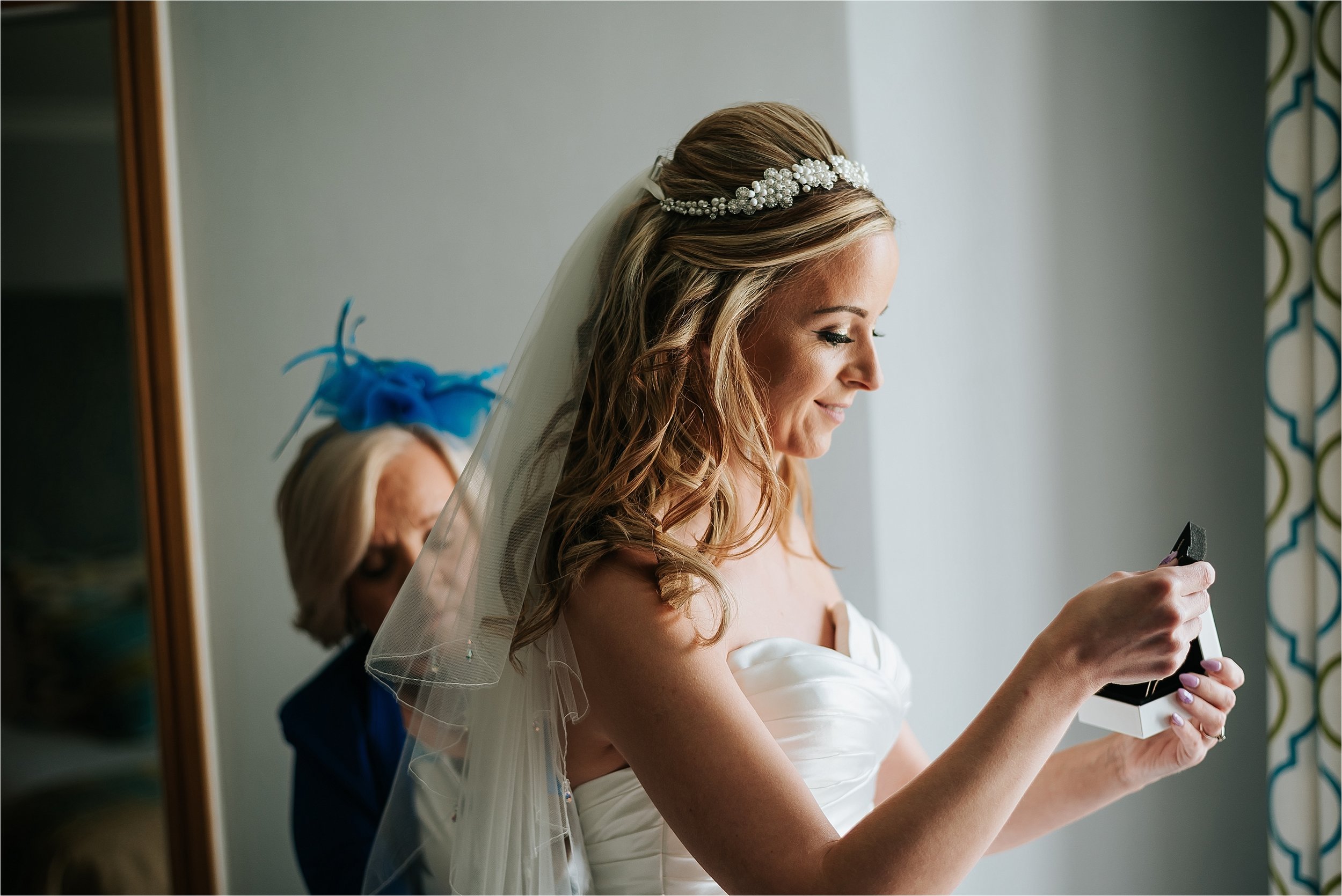 bride putting jewellery on before wedding 