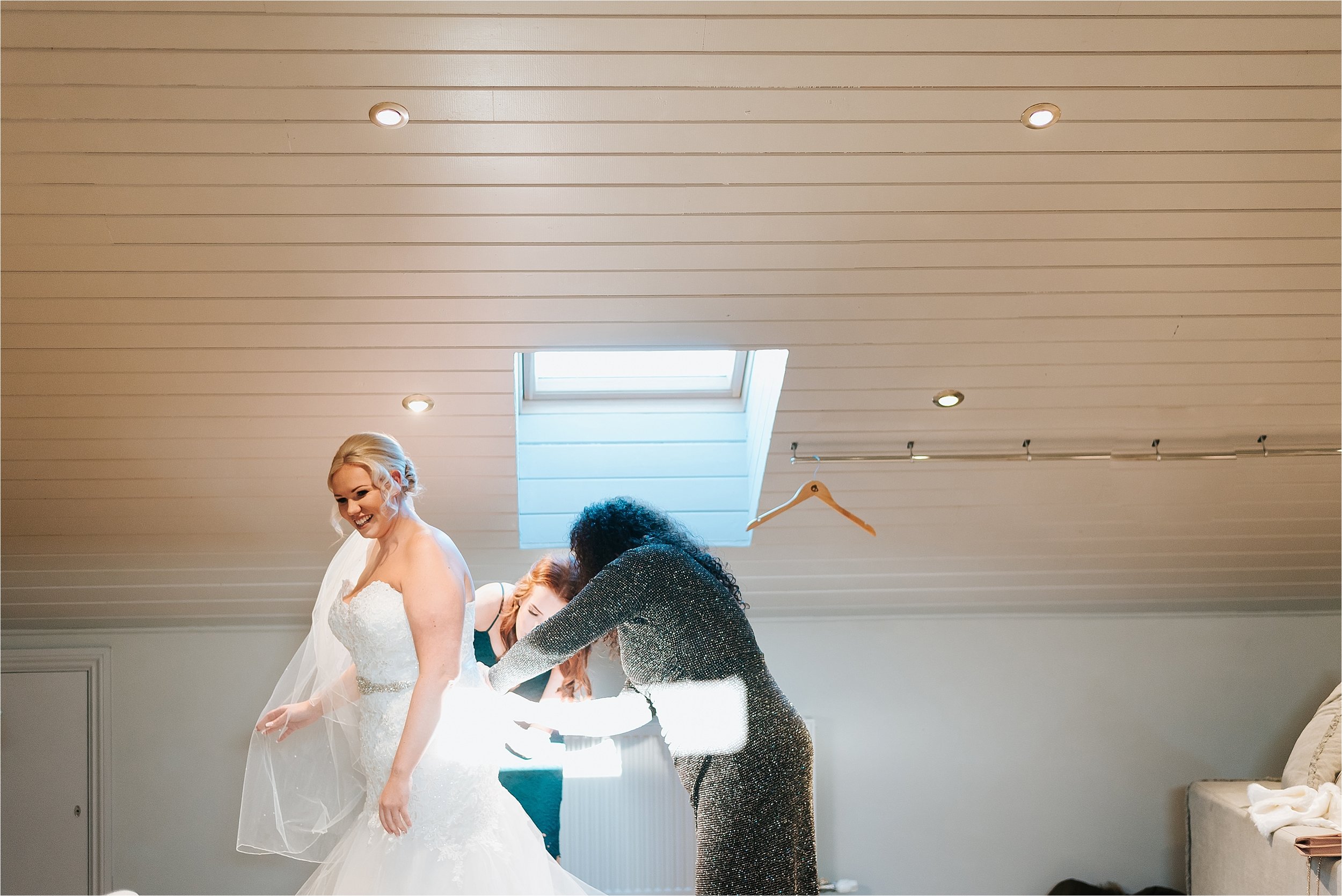 bride putting wedding dress on 