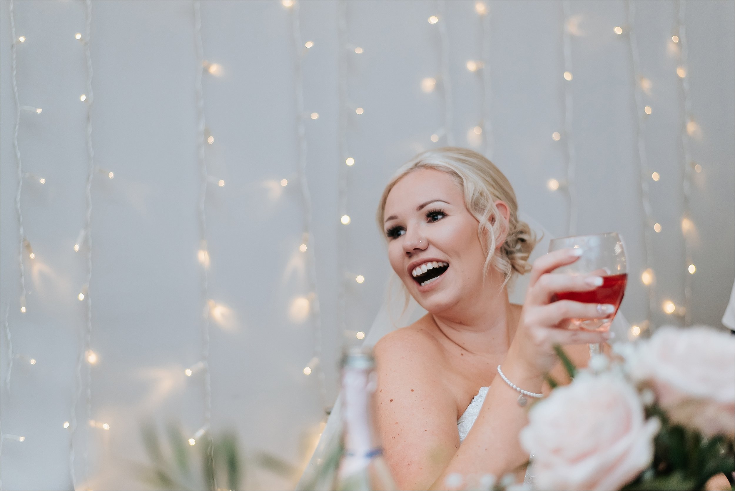 bride laughing at wedding speeches 