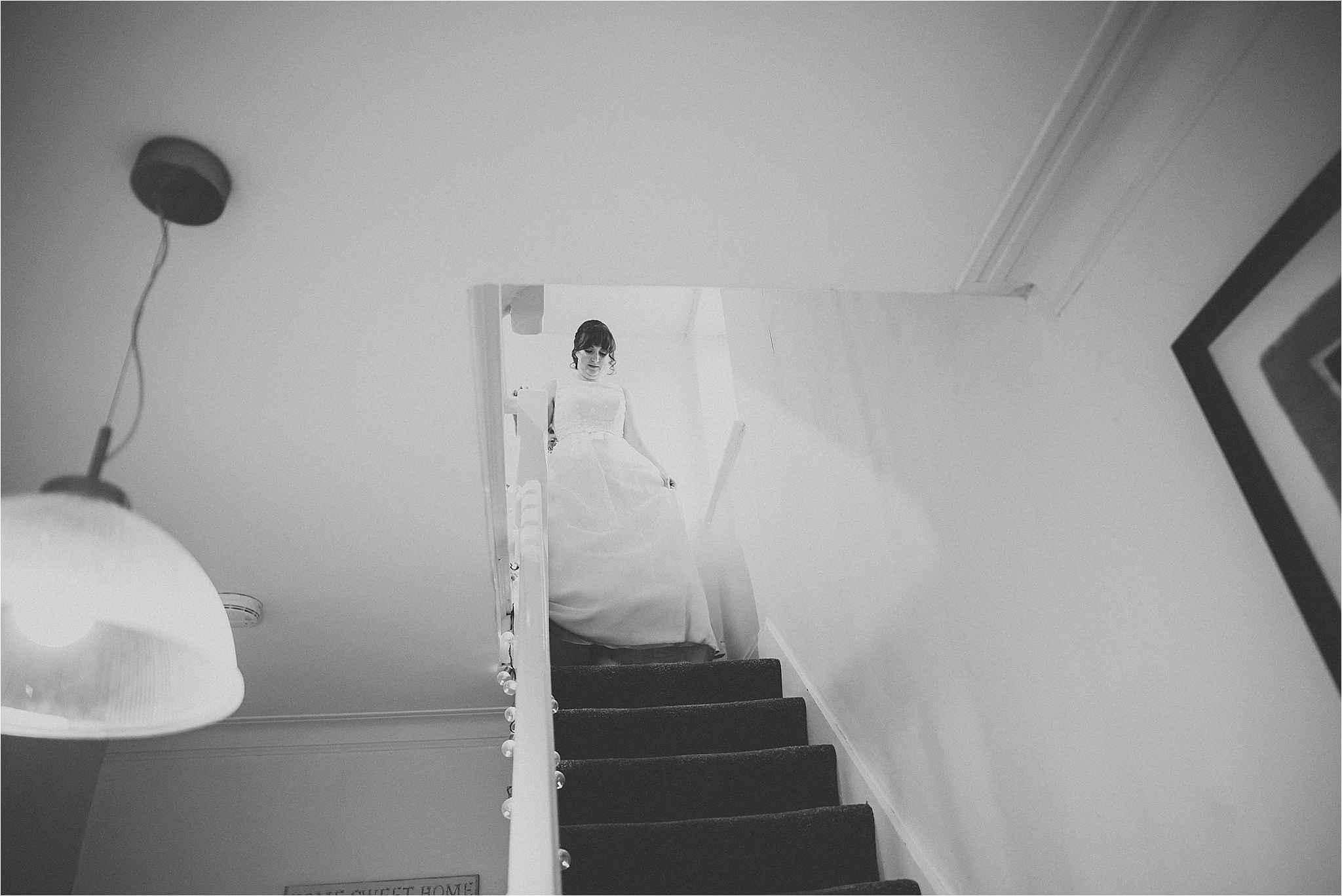 bride walks down stairs in charlotte balbier gown