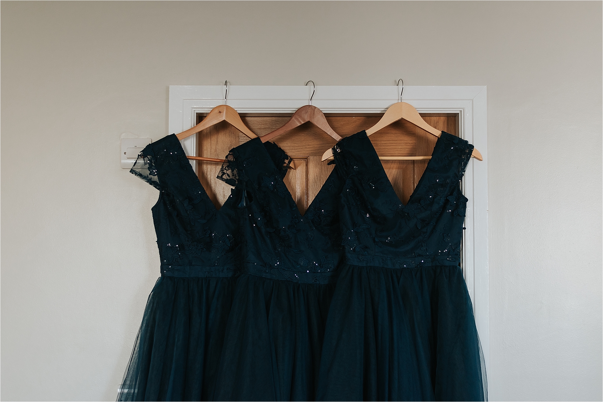 bridesmaid dresses hanging on door 