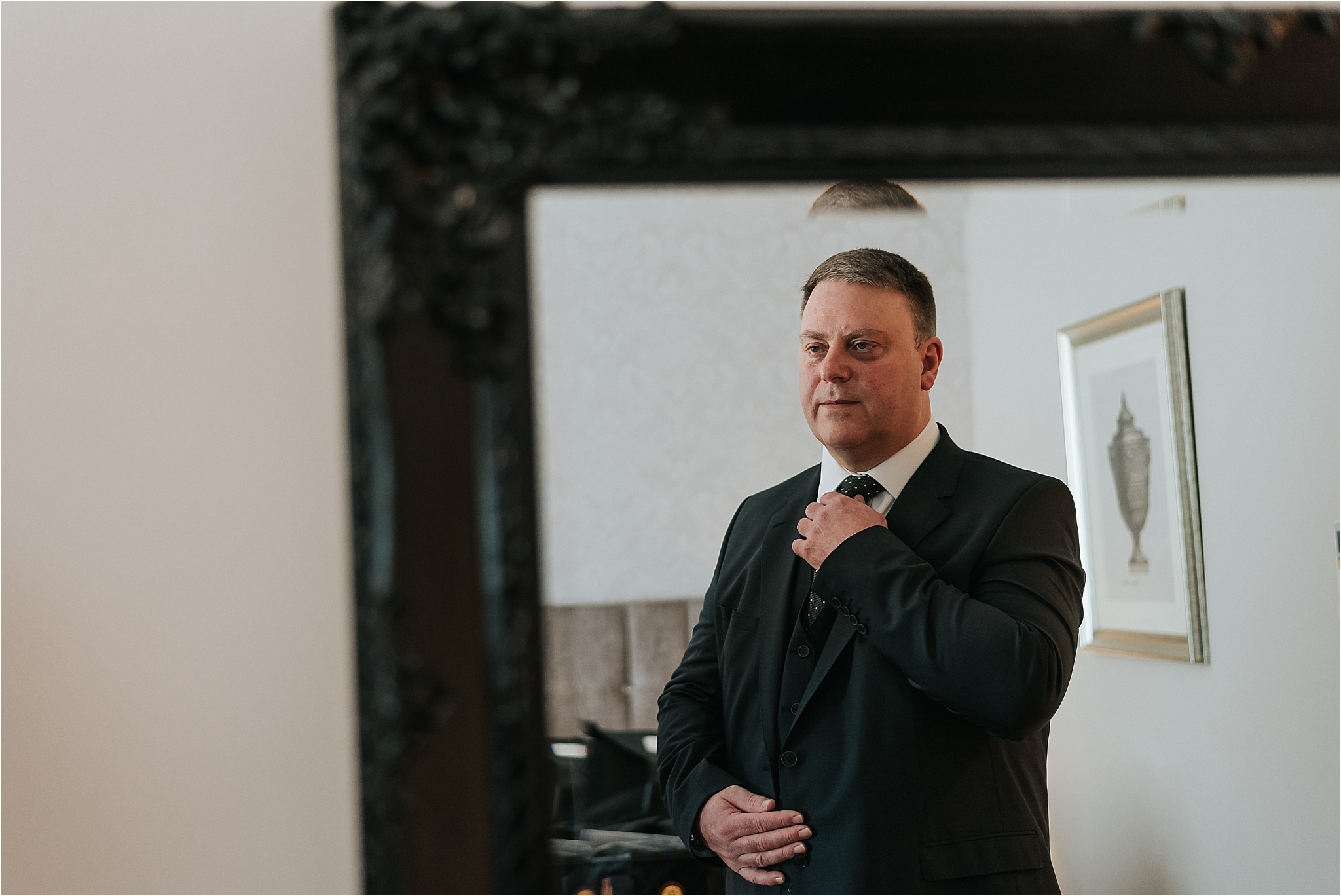 groom puts his tie on at wedding at the villa 