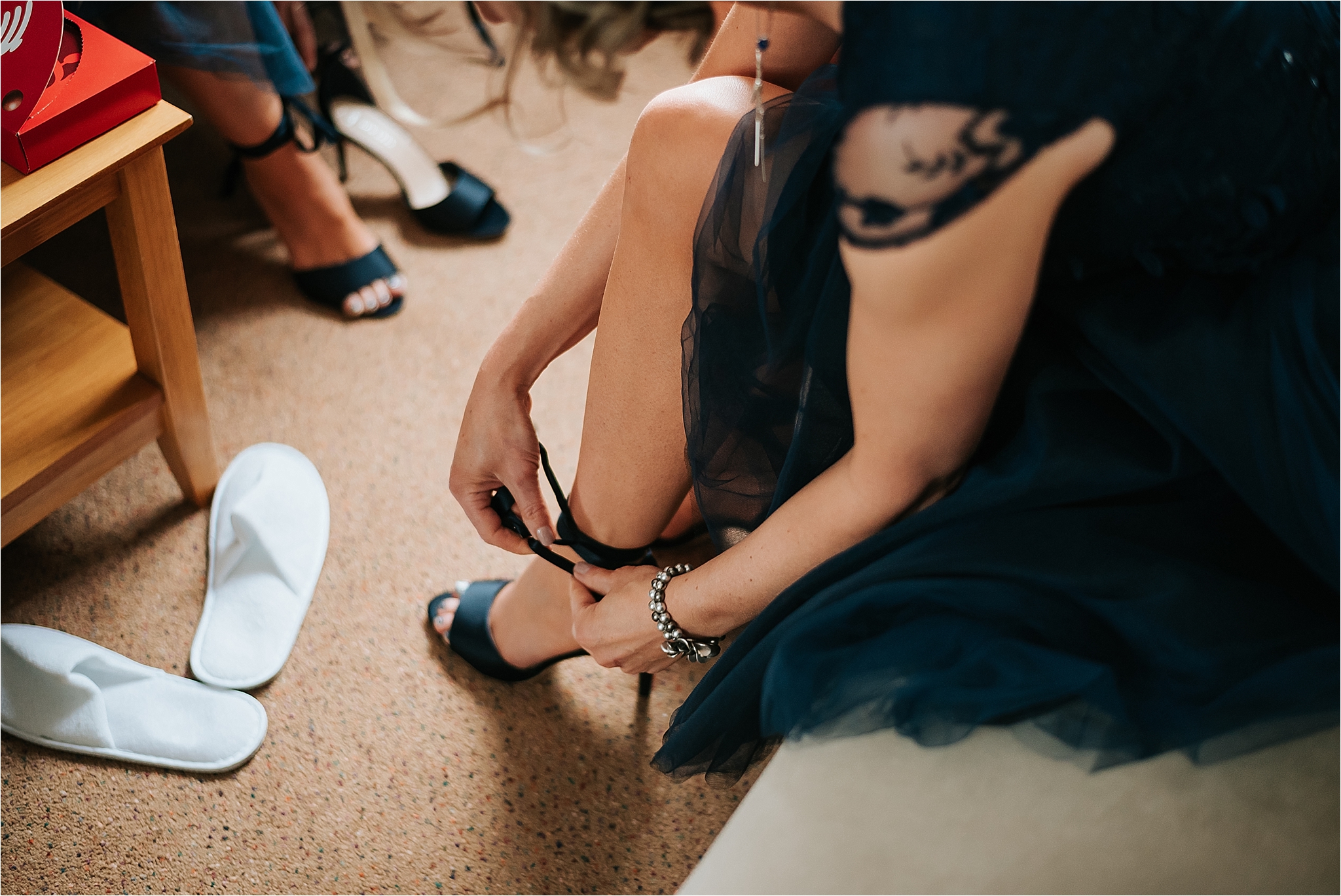 bridesmaid putting her shoes on at wedding 
