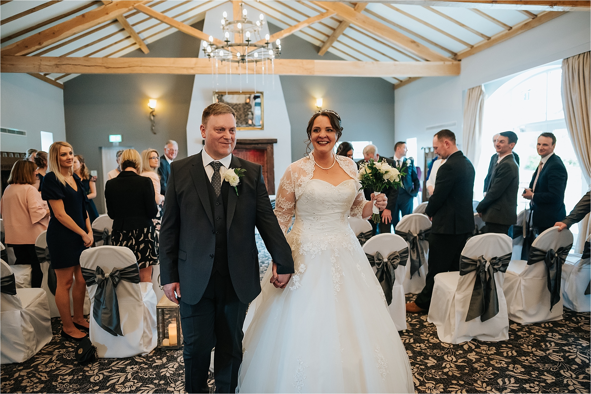 newly married couple walk out of ceremony room