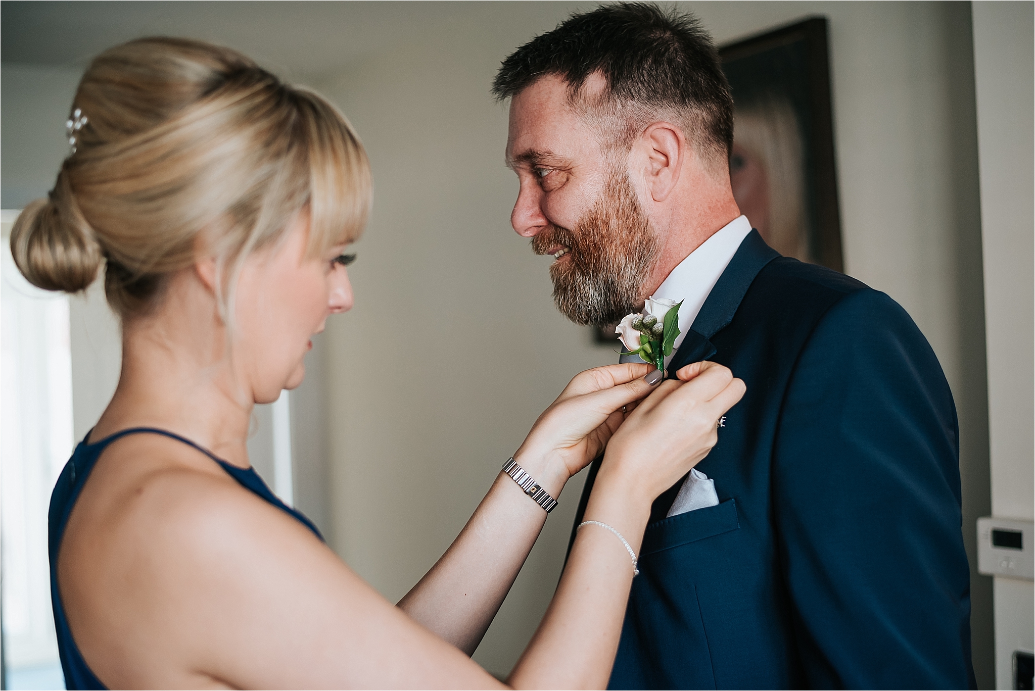 bridesmaid helps dad put his buttonhole on
