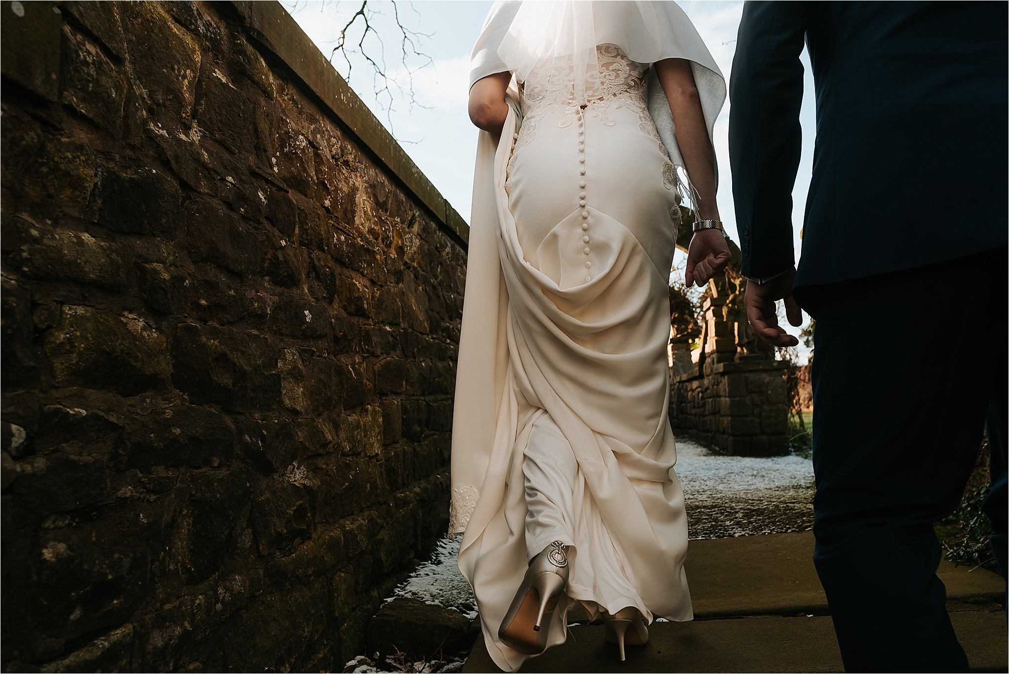 romantic image of bride and groom holding hands at wedding
