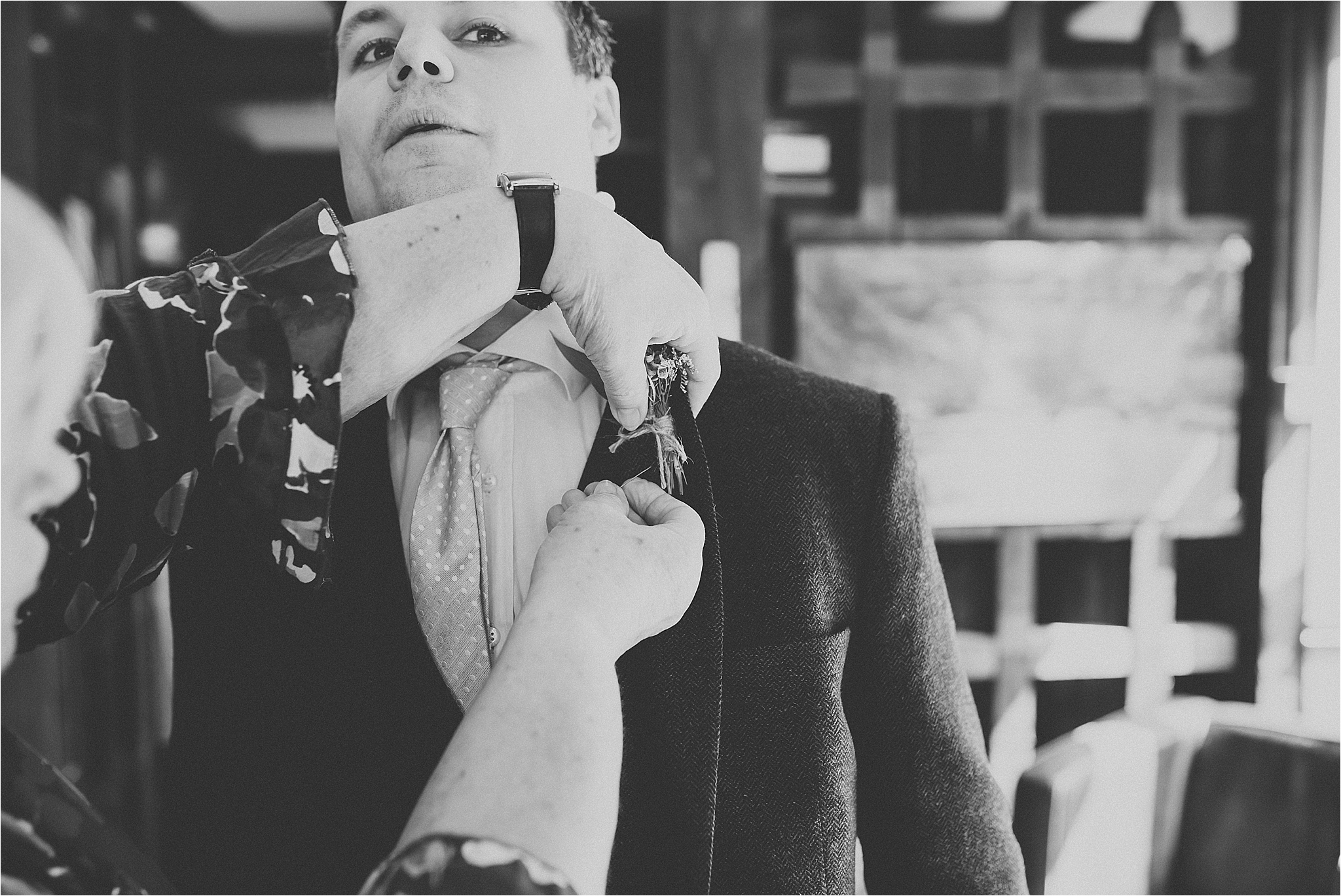 groomsman puts button hole on