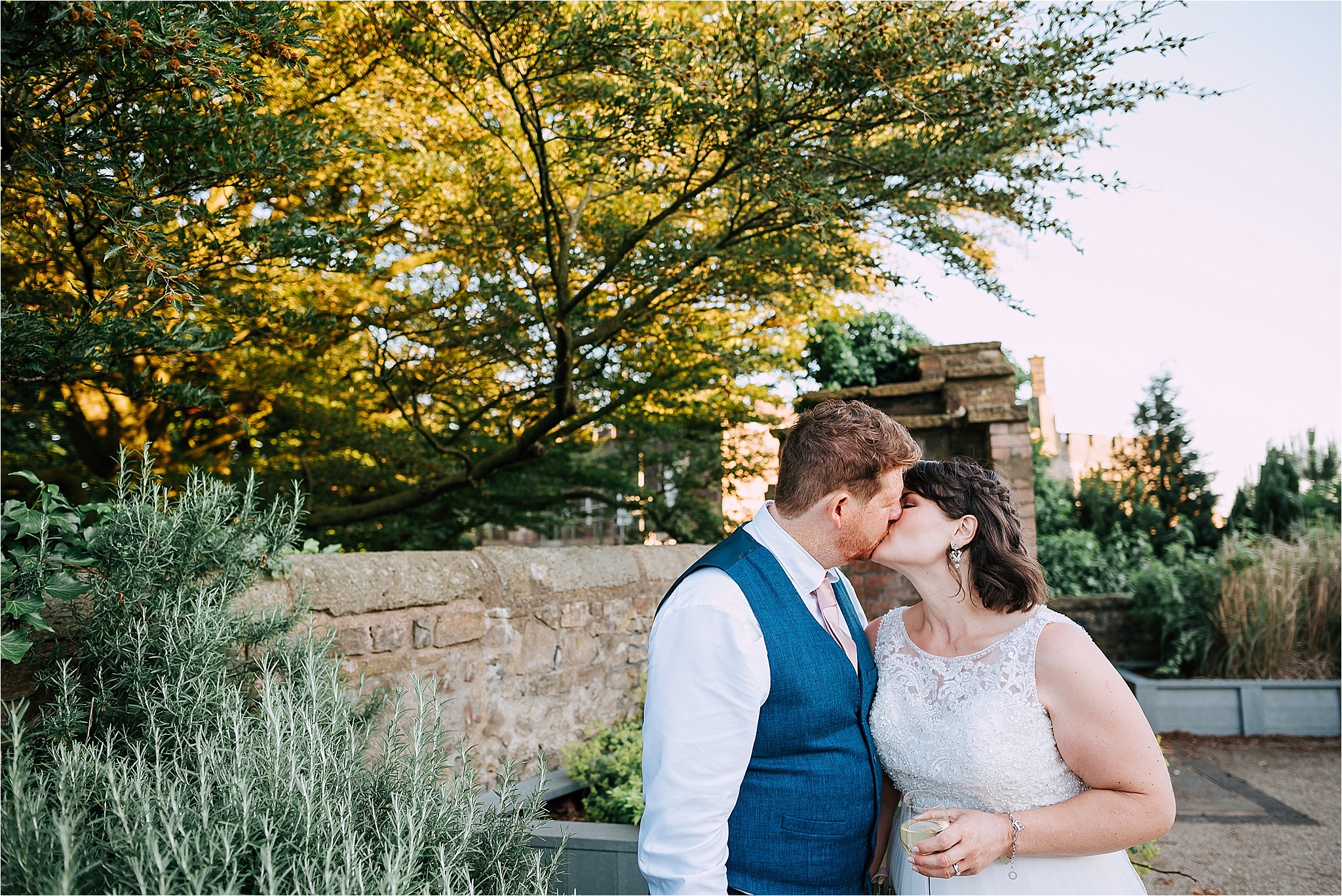 Bride and groom kissing at wedding in front of clitheroe castle
